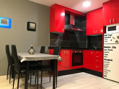 a kitchen with red cabinets and a table with chairs at lucushouse I in Lugo