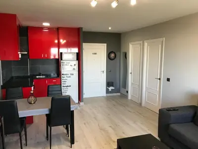a kitchen and living room with red cabinets and a table at lucushouse I in Lugo