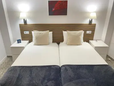 a bedroom with two beds and two night stands at Apartamento Padrón Centro P1 by URent in Padrón