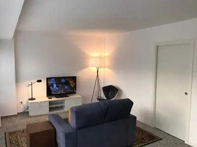 a living room with a blue couch and a television at Apartamento Padrón Centro P1 by URent in Padrón