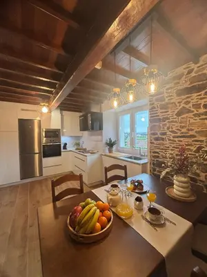 a kitchen with a table with a bowl of fruit on it at Casa Tarrío con Piscina - Santiago de Compostela in Boqueijón
