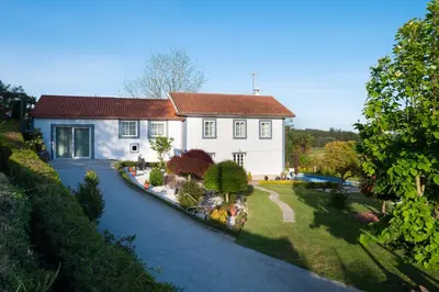 a large white house with a garden in front of it at Casa Tarrío con Piscina - Santiago de Compostela in Boqueijón
