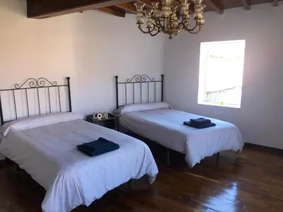 a room with two beds and a chandelier at A Casa do Chico in Ourense