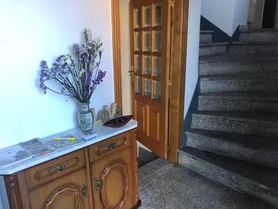 a vase of flowers on a cabinet next to a staircase at A Casa do Chico in Ourense