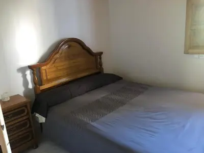 a bedroom with a bed with a wooden headboard and a night stand at A Casa do Chico in Ourense