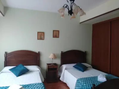 a bedroom with two beds with blue pillows at jucar carmen in Santiago de Compostela