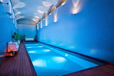 a large swimming pool in a room with aperature at Parador de Corias in Cangas del Narcea