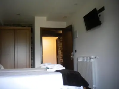 a bedroom with a bed and a television on the wall at Casa de Aldea Araceli in Berducedo