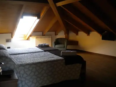a bedroom with a bed and a chair in a attic at Casa de Aldea Araceli in Berducedo