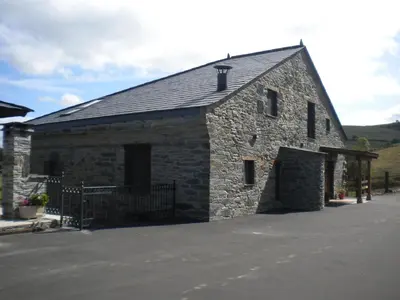 a large stone building with a black roof at Casa de Aldea Araceli in Berducedo