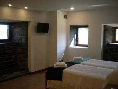 a hotel room with two beds and a fireplace at Casa de Aldea Araceli in Berducedo