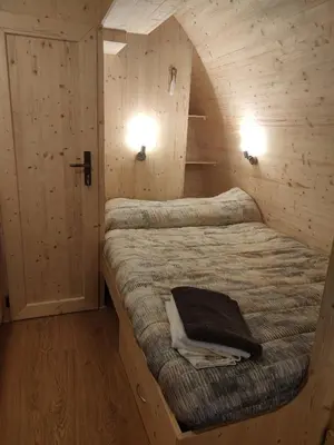 a bedroom with a bed in a wooden cabin at TEIRABOA BASE CAMP in Arzúa