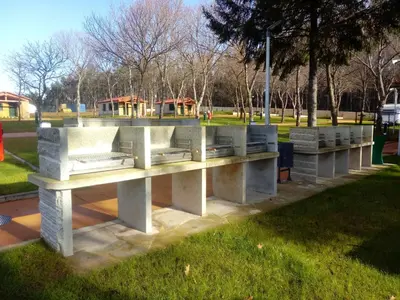 a concrete bench in a park with a playground at TEIRABOA BASE CAMP in Arzúa