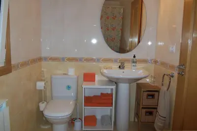 a bathroom with a white toilet and a sink at La Casa de Lines in Monforte de Lemos