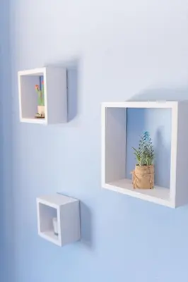 a white shelf with a plant in a basket on a wall at Apartamento Ultreia in Palas de Rei
