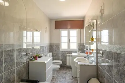 a bathroom with two sinks and a toilet and a sink at Apartamento Ultreia in Palas de Rei