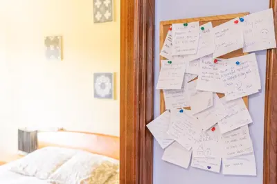 a mirror with notes on a wall next to a bed at Apartamento Ultreia in Palas de Rei