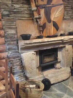a stone fireplace with two pans on top of it at Cabaña - A Pastoriza - Lugo in Baltar