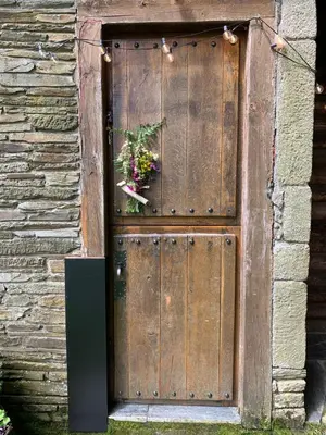 a wooden door with a flower arrangement on it at Cabaña - A Pastoriza - Lugo in Baltar
