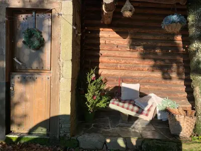 a wooden building with a bench and a door at Cabaña - A Pastoriza - Lugo in Baltar