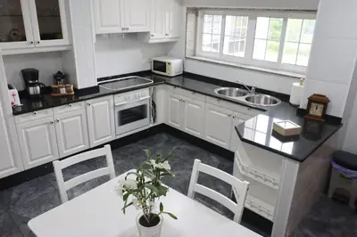 a kitchen with white cabinets and a table with chairs at El piso de Manuela VUT-CO-004057 in Padrón