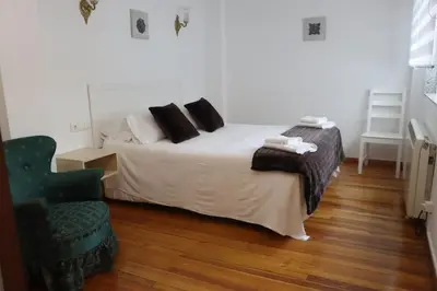 a bedroom with a bed and a chair in it at El piso de Manuela VUT-CO-004057 in Padrón