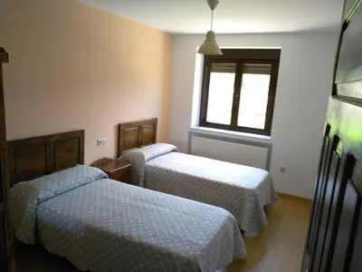a room with two beds and a window at Casa Valdequiruelo in Vanidodes