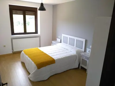 a bedroom with a large bed with a yellow blanket at Casa Valdequiruelo in Vanidodes