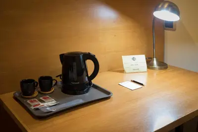 a black coffee pot on a tray on a desk at Hotel Roma in Sarria