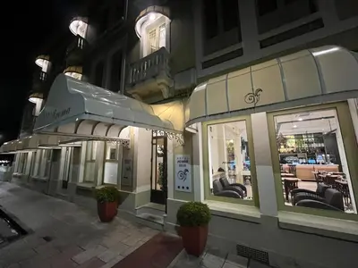 a row of shops on a city street at night at Hotel Roma in Sarria