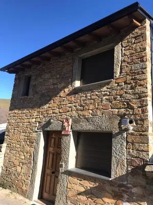 a brick building with a door and two windows at El Pajar in San Ciprián