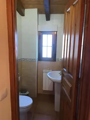 a bathroom with a sink and a toilet and a window at El Pajar in San Ciprián