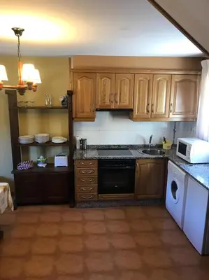 a kitchen with wooden cabinets and a stove top oven at El Pajar in San Ciprián