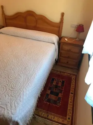 a bedroom with a bed and a dresser with a lamp at El Pajar in San Ciprián