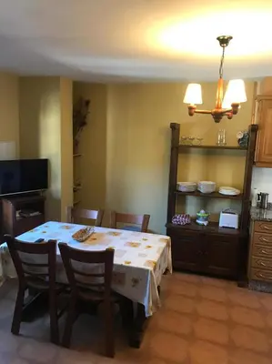 a dining room with a table and chairs and a kitchen at El Pajar in San Ciprián