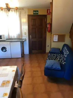 a living room with a blue couch and a table at El Pajar in San Ciprián
