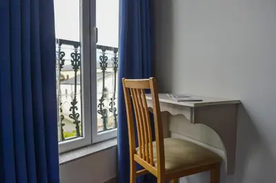 a desk with a chair in front of a window at Hostal Linares in Ribadeo