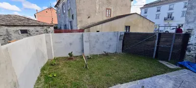 a fence in front of a building with a yard at Casa entera en Nois-Foz in Nois