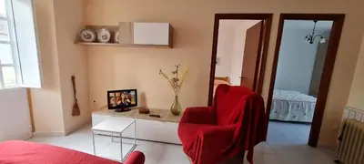 a living room with a red chair and a table at Casa entera en Nois-Foz in Nois