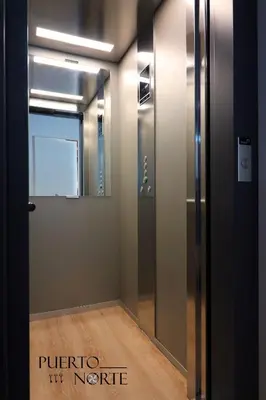 a elevator in a room with a glass door at Apartamentos Puerto Norte - Apto 1 in Puerto de Vega
