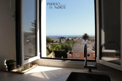 a kitchen window with a view of a house at Apartamentos Puerto Norte - Apto 1 in Puerto de Vega