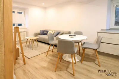 a living room with a table and chairs and a couch at Apartamentos Puerto Norte - Apto 1 in Puerto de Vega