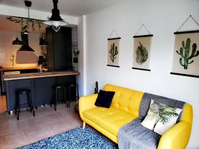 a living room with a yellow couch and a kitchen at Pintoresco piso a 5 min de la playa wifi/Netflix in Ares