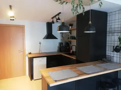 a kitchen with black cabinets and a counter top at Pintoresco piso a 5 min de la playa wifi/Netflix in Ares