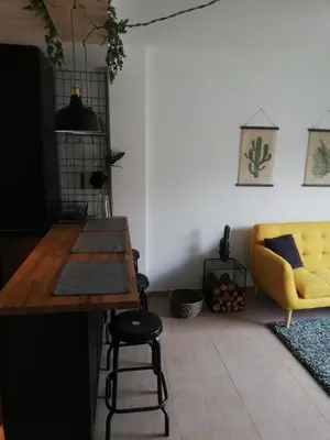 a living room with a yellow couch and a table at Pintoresco piso a 5 min de la playa wifi/Netflix in Ares