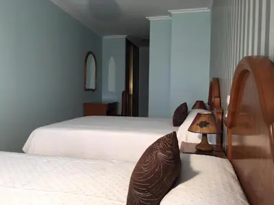 a bedroom with two beds and a table with a lamp at Villa De Foz in Foz