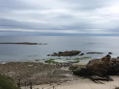 a beach with some rocks in the water at Villa De Foz in Foz