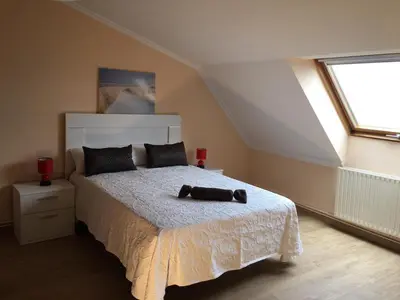 a bedroom with a bed with a white bedspread and a window at Villa De Foz in Foz