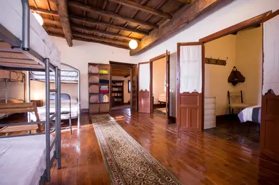 a room with bunk beds and a wooden floor at Albergue Rectoral de Romean in Lugo