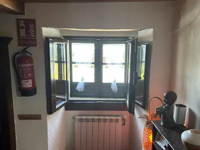 a kitchen with a window with two birds in it at Albergue Rectoral de Romean in Lugo